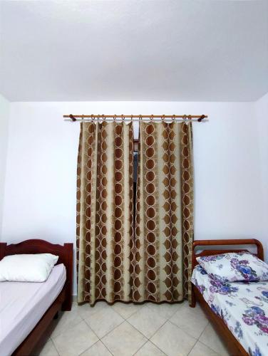 a bedroom with two beds and a curtain at Memory Tirana Apartments in Tirana