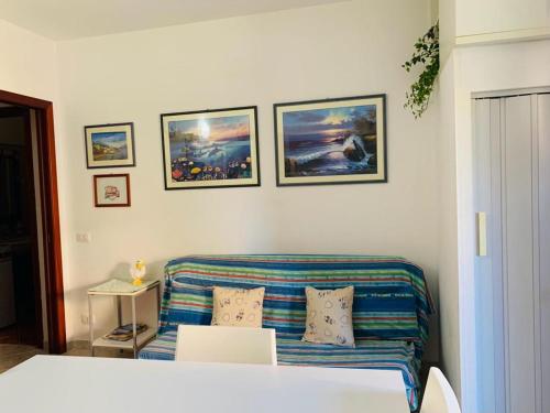 a living room with a couch and pictures on the wall at Valledoria Residenza sole e mare in Codaruina
