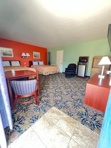 Cette chambre comprend deux lits et un bureau. dans l'établissement Town & Country Motel, à Sioux City