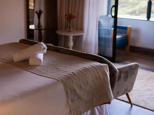 a hotel room with a bed with towels on it at Pousada Suiça Mineira Centro in Monte Verde