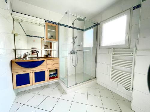 a bathroom with a glass shower and a sink at Lumineux 2 pièces Paris nord-est in Pantin
