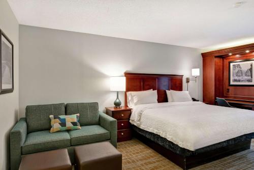 a hotel room with a bed and a chair at Hampton Inn Beckley in Beckley