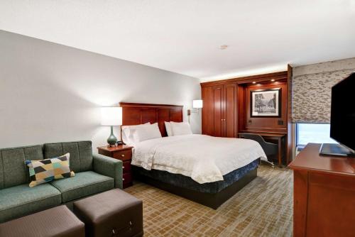 a hotel room with a bed and a couch at Hampton Inn Beckley in Beckley