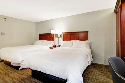 two beds in a hotel room with white sheets at Hampton Inn Beckley in Beckley