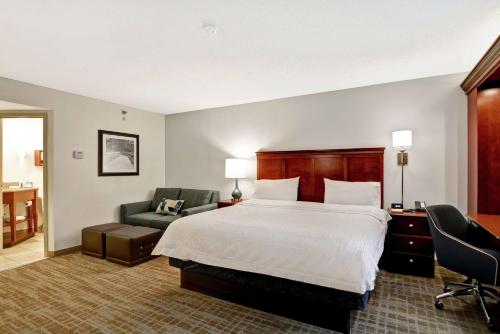 a hotel room with a bed and a chair at Hampton Inn Beckley in Beckley