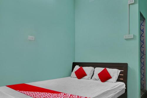 a bed with red and white pillows in a room at OYO Flagship 81188 New Sharda Homes in Bilāspur