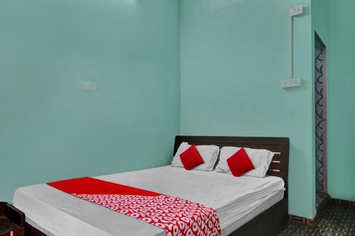 a bedroom with a bed with red and white pillows at OYO Flagship 81188 New Sharda Homes in Bilāspur