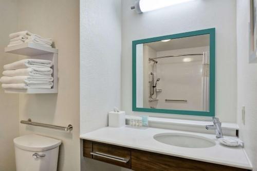 a white bathroom with a sink and a mirror at Hampton Inn & Suites Boynton Beach in Boynton Beach