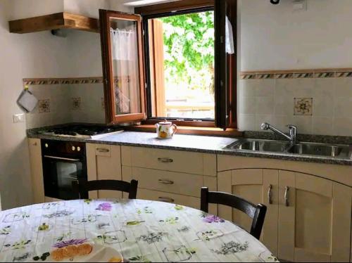 a kitchen with a table and a sink and a window at Casa della Meridiana in Clastra