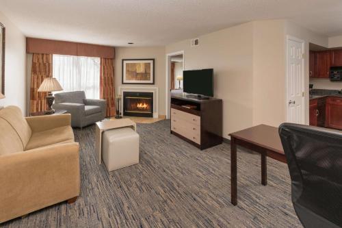 a living room with a couch and a television at Homewood Suites by Hilton Chicago - Schaumburg in Schaumburg