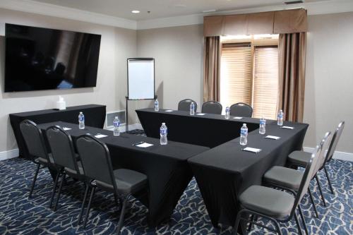 a conference room with tables and chairs and a screen at Homewood Suites by Hilton Chicago - Schaumburg in Schaumburg