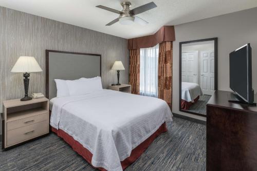 a hotel room with a bed and a television at Homewood Suites by Hilton Chicago - Schaumburg in Schaumburg