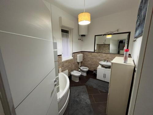 カリーニにあるCamera relax riservata intero appartamentoのバスルーム(トイレ2つ、バスタブ、シンク付)