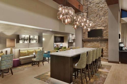 um átrio com um bar com cadeiras e uma sala de estar em Hampton Inn and Suites Springdale em Springdale