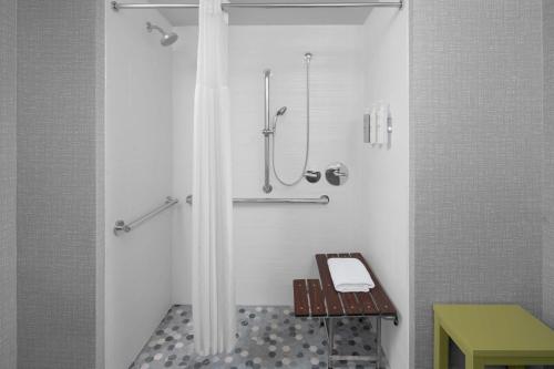 a bathroom with a shower with a bench in it at Hampton Inn & Suites Grand Rapids-Airport 28th St in Cascade