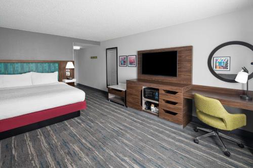 a hotel room with a bed and a desk and a tv at Hampton Inn & Suites Grand Rapids-Airport 28th St in Cascade