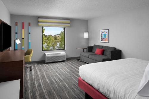 a hotel room with a bed and a couch at Hampton Inn & Suites Grand Rapids-Airport 28th St in Cascade