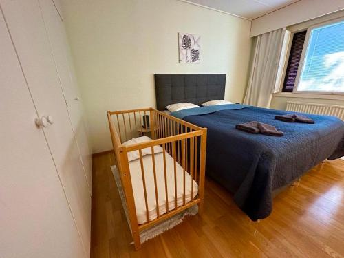 1 dormitorio con 1 cama con manta azul y ventana en Miramar Mariehamn Åland, en Mariehamn