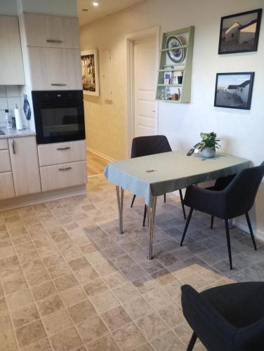 a kitchen and dining room with a table and chairs at Thy drop in in Thisted