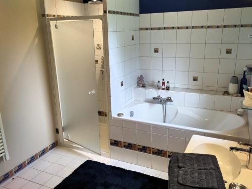 a bathroom with a shower and a tub and a sink at B&B chez Frédérique et Norbert in Mogneneins