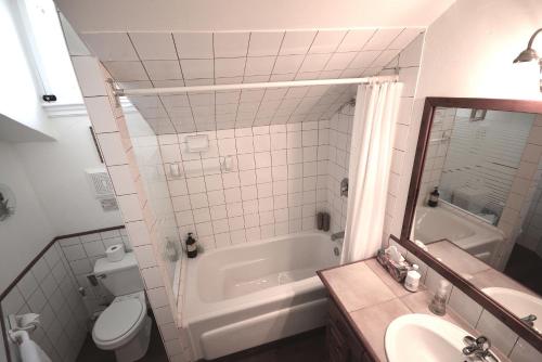 a bathroom with a tub and a toilet and a sink at 1842 Bed & Breakfast in St. Jacobs
