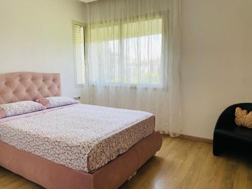 Un dormitorio con una cama grande y una ventana en Prestigia Golf city Bouskoura Apartment, en Bouskoura