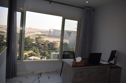 a room with a desk and a large window at pyramids grand museum inn in Cairo