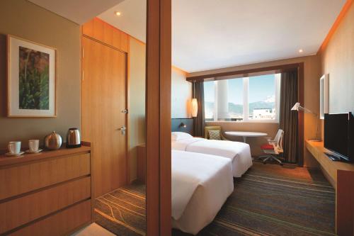 a hotel room with two beds and a television at Hilton Garden Inn Lijiang in Lijiang