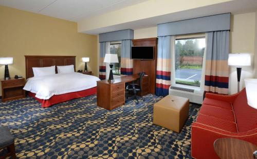 リンチバーグにあるHampton Inn and Suites Lynchburgのベッド、デスク、椅子が備わるホテルルームです。