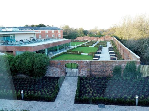 um edifício de tijolos com um pátio com um jardim em DoubleTree by Hilton Chester em Chester
