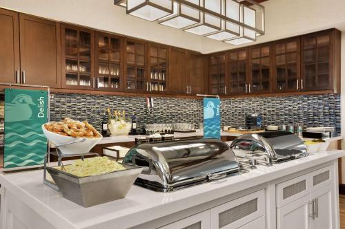 a kitchen with a counter with some food on it at Homewood Suites by Hilton Kansas City Airport in Kansas City