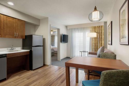 a kitchen and a living room with a table in a room at Homewood Suites by Hilton Kansas City Airport in Kansas City
