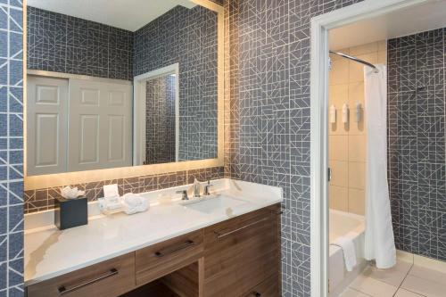 e bagno con lavandino, specchio e vasca. di Homewood Suites by Hilton New Orleans a New Orleans