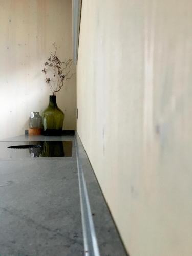 a vase sitting on the floor next to a wall at KampenZeit Loft mit traumhaftem Panoramablick in Aschau im Chiemgau
