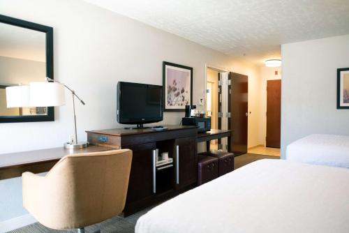 a hotel room with a bed and a desk with a television at Hampton Inn Oklahoma City-Northwest in Oklahoma City
