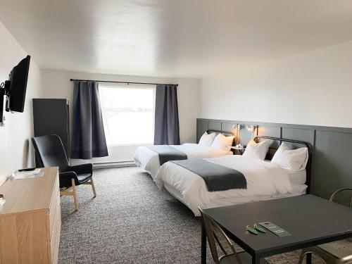 a hotel room with two beds and a table at The Bayview Motel - Fort Frances, ON - Lakeside Motel in Fort Frances