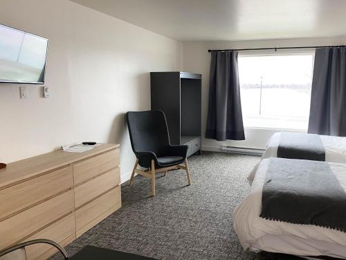 a hotel room with a bed and a chair in it at The Bayview Motel - Fort Frances, ON - Lakeside Motel in Fort Frances