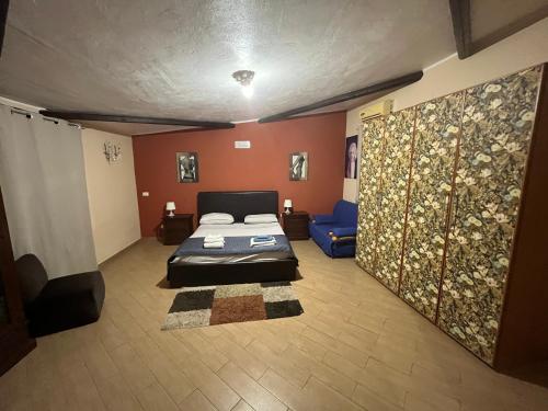 カリーニにあるCamera relax riservata intero appartamentoのベッドルーム(ベッド1台、青いソファ付)