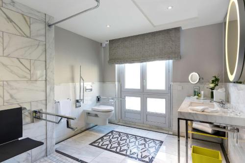 a bathroom with a shower and a toilet and a sink at Hilton Paris Opera in Paris