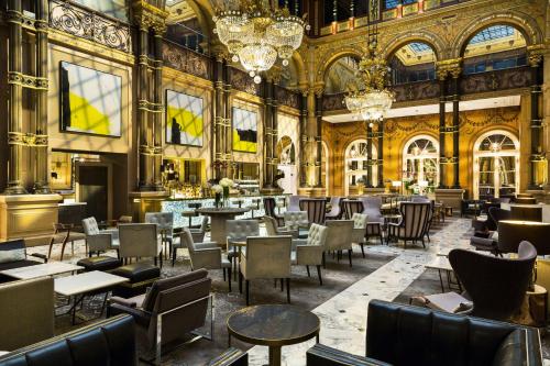 un restaurant avec des tables et des chaises dans un bâtiment dans l'établissement Hilton Paris Opera, à Paris