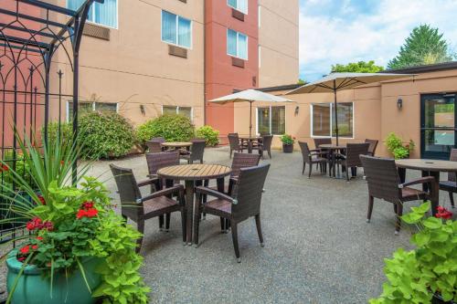 eine Außenterrasse mit Tischen, Stühlen und Pflanzen in der Unterkunft DoubleTree by Hilton Portland Tigard in Tigard