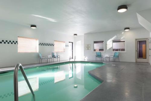 una piscina con sillas azules en un edificio en DoubleTree by Hilton Portland Tigard, en Tigard
