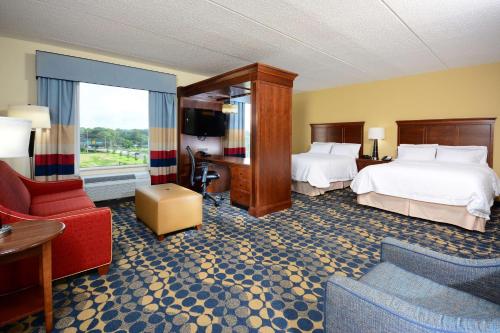 une chambre d'hôtel avec deux lits et un canapé dans l'établissement Hampton Inn & Suites Durham North I-85, à Durham