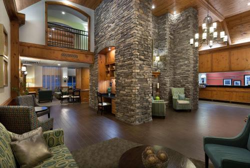 a lobby of a hotel with a stone wall at Hampton Inn & Suites Charlotte/Pineville in Charlotte