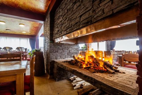a fireplace in a restaurant with a brick wall at Hacienda del Valle Sagrado in Urubamba