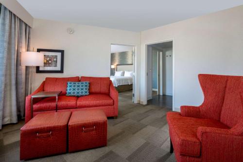 a living room with red furniture and a bed at Hampton Inn Santa Barbara/Goleta in Santa Barbara