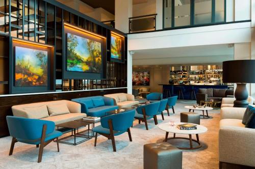 a lobby with tables and chairs and a bar at Marriott Hotel The Hague in The Hague