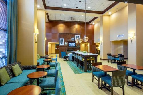 a lobby with tables and chairs and a cafeteria at Hampton Inn & Suites Sacramento-Elk Grove Laguna I-5 in Elk Grove