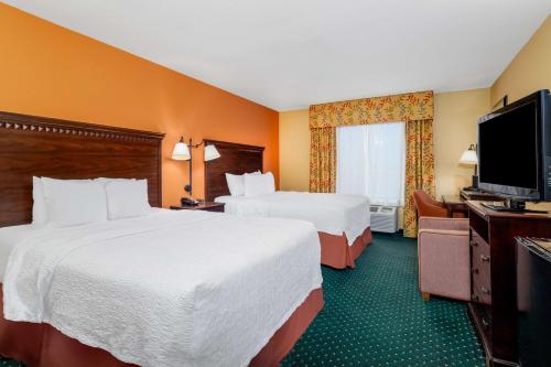 a hotel room with two beds and a flat screen tv at Hampton Inn & Suites Sacramento-Elk Grove Laguna I-5 in Elk Grove