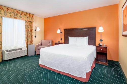 a hotel room with a large bed and a chair at Hampton Inn & Suites Sacramento-Elk Grove Laguna I-5 in Elk Grove